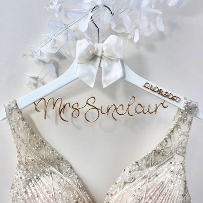 Bridal gown on a personalized hanger with 'Mrs Sinclair' on a light background