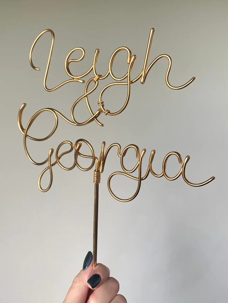 a close up detail of a bronze gold wire wedding cake topper
