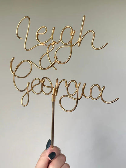 a close up detail of a bronze gold wire wedding cake topper