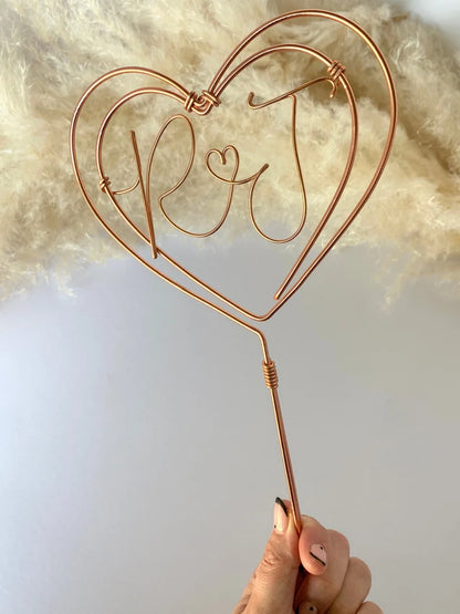 copper wire cake topper, in a heart shape with couples’ initials in the middle