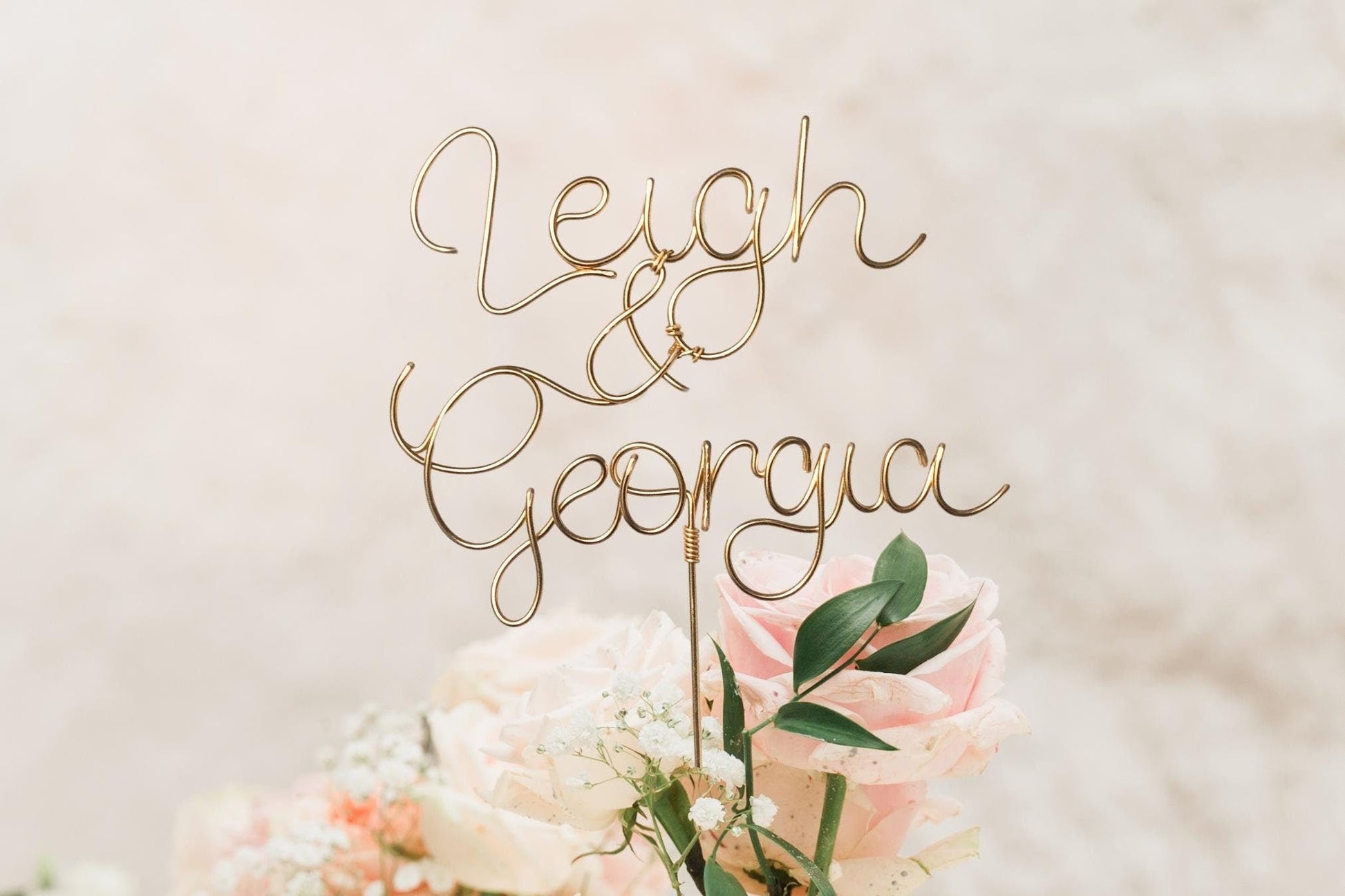 wedding cake topper in bronze gold wire, with couple’s names intertwined 