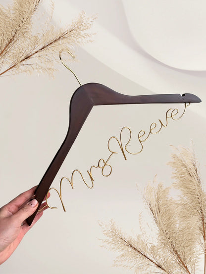 dark wood wedding hanger for bride to be, with personalised wire name in bronze gold