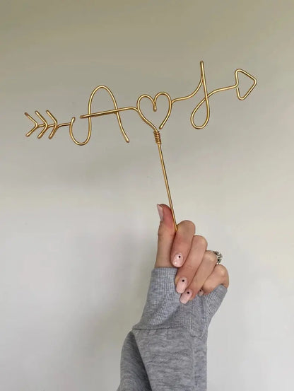 custom made cake topper, with couples initials, designed to look like cupids arrow