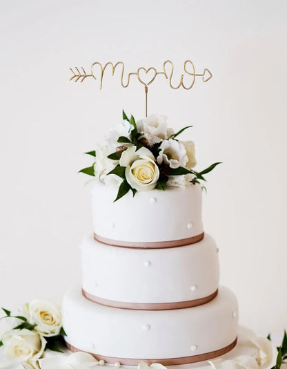 personalised wire arrow cake topper, with couples initials, on top of white wedding cake with floral details