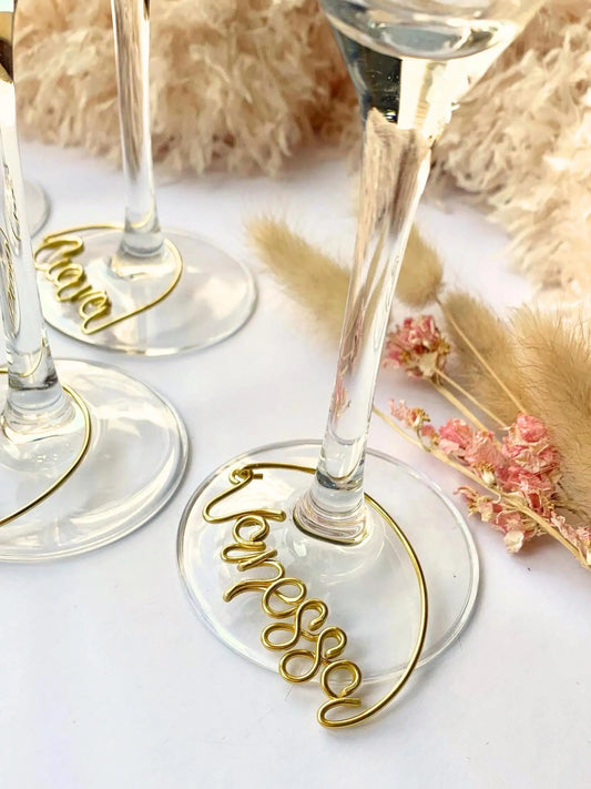 personalised wire wine glass charms, drinks tag with name custom made in wire, around the stem of a champagne flute